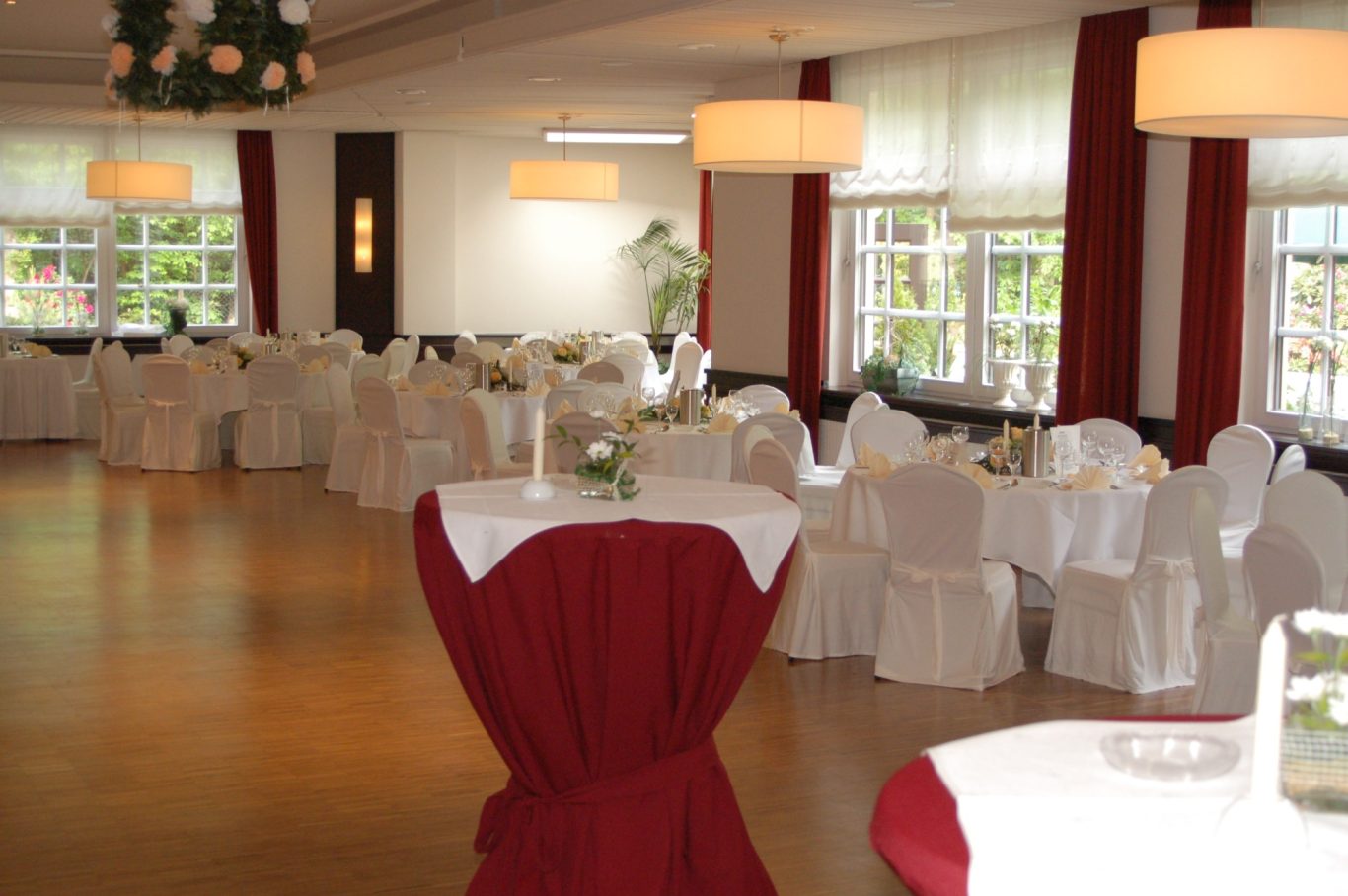 Saal mit runden Tischen & Hussen